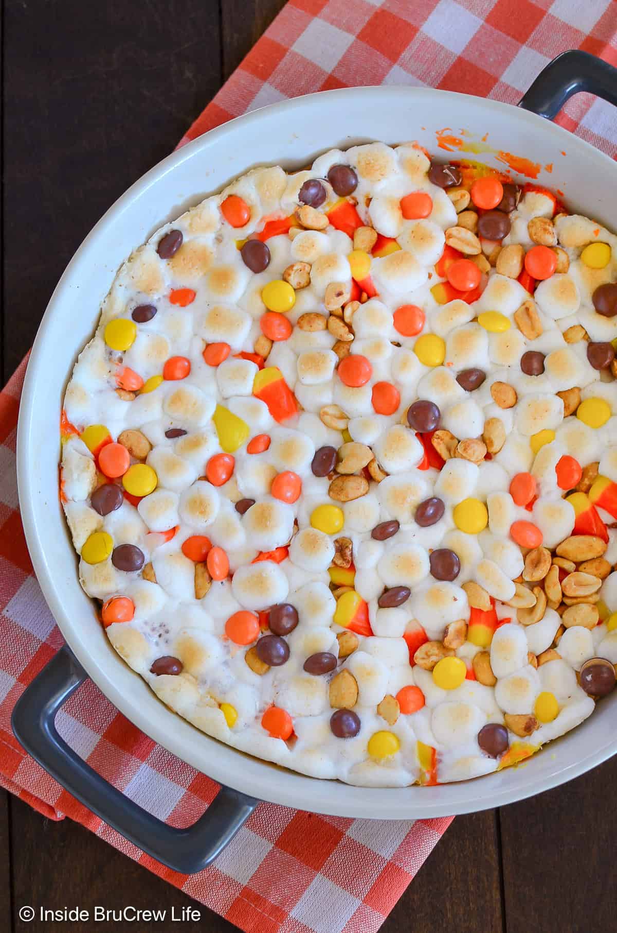 A peanut butter cookie pizza topped with marshmallows and a fall snack mix.