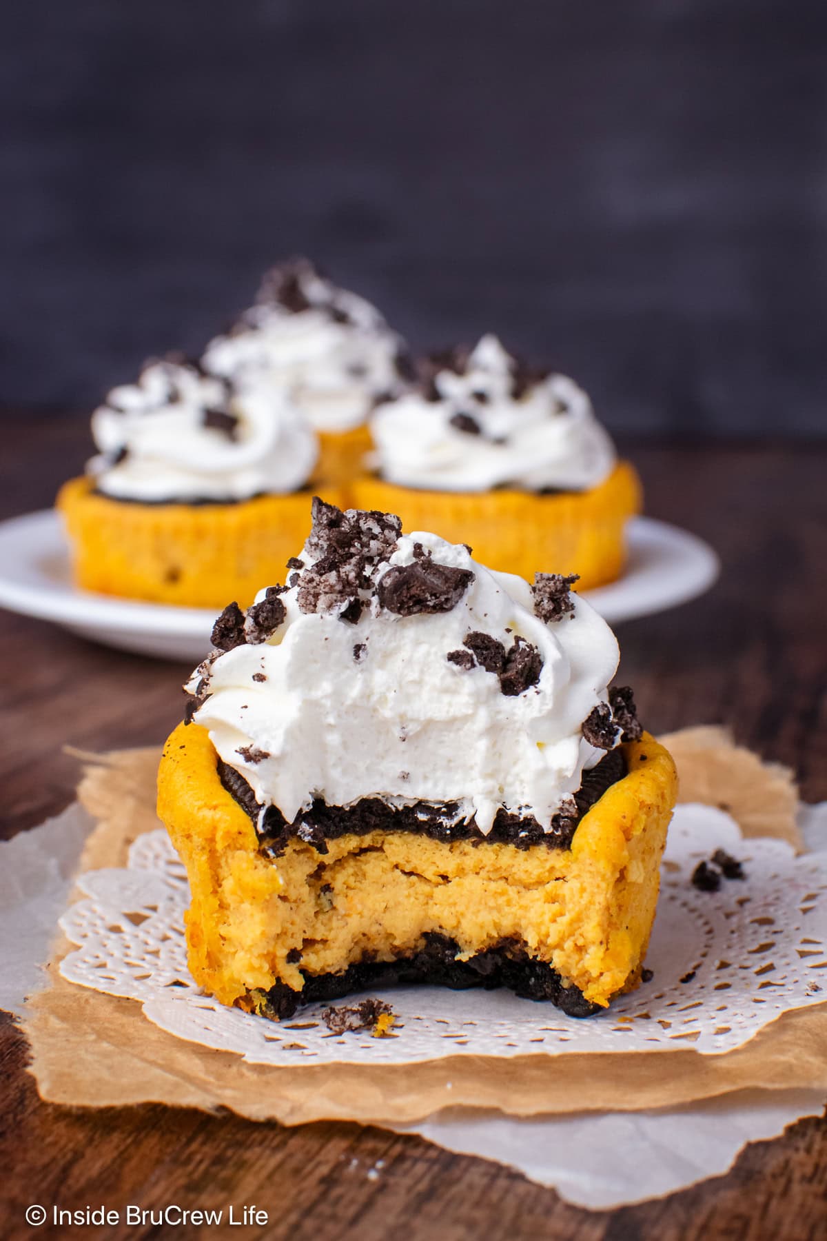 A mini pumpkin cheesecake with a bite out of it.