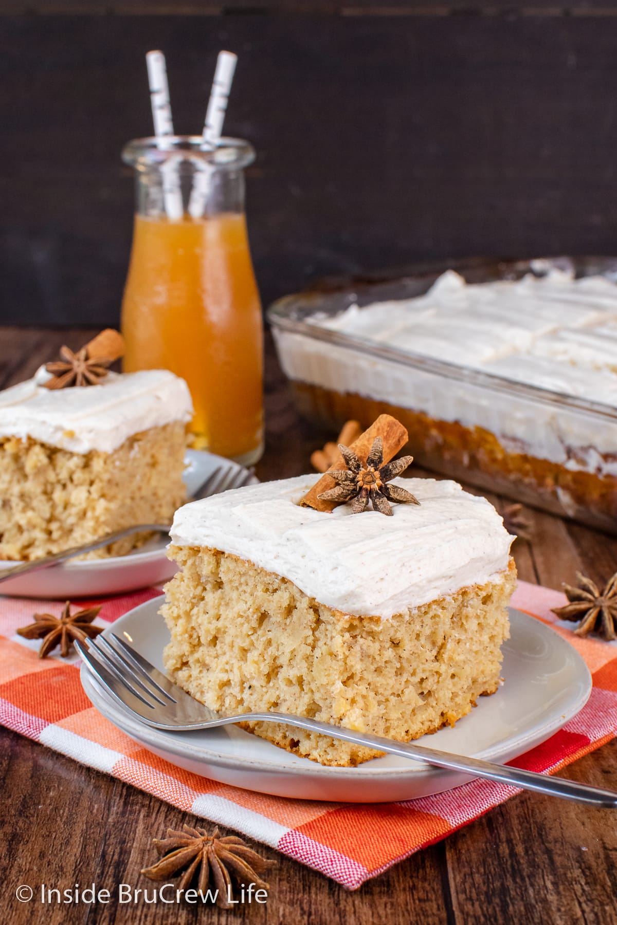 Two squares of frosted cake on plates.