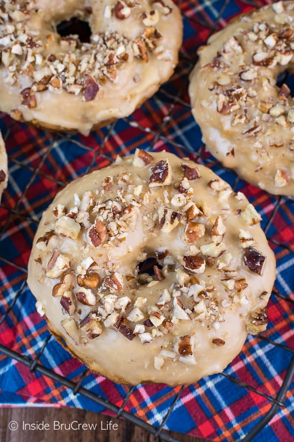 Apple Praline Donuts - a sweet praline glaze and pecans make these soft baked apple donuts taste amazing. Make this easy recipe for cool fall mornings. It's the perfect breakfast with hot cider! #donuts #apple #pecans #praline #homemade #bakeddonuts #fall #recipes #breakfast #brunch #afterschoolsnack