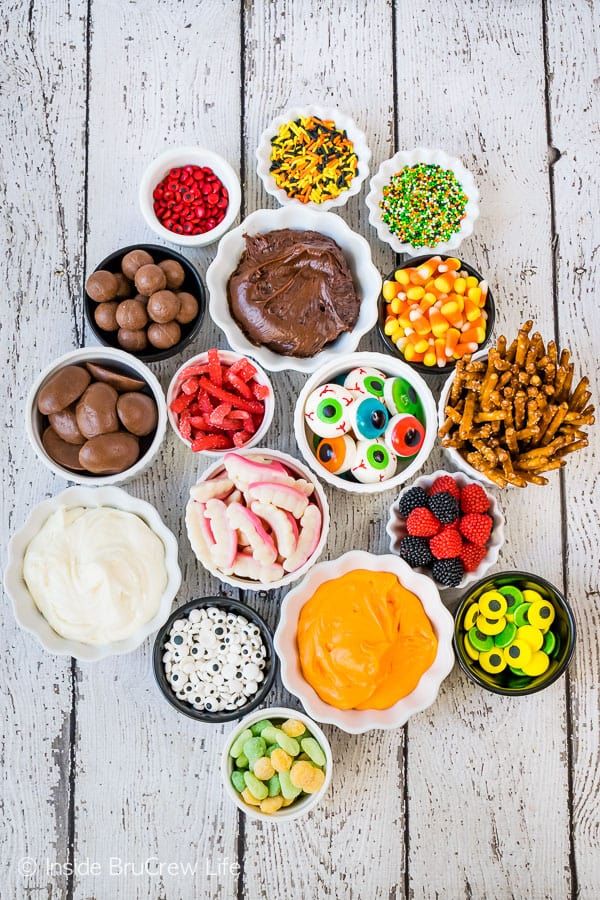 A white board with bowls of ingredients to decorate monster sugar cookies.