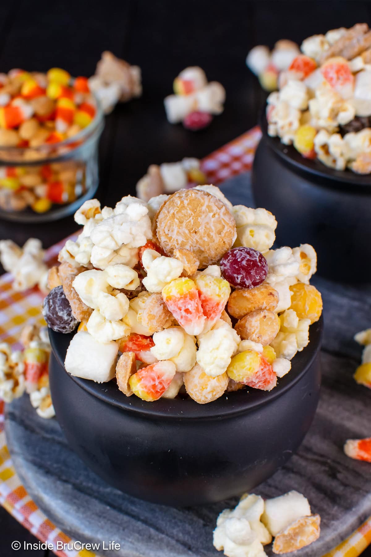 Two black bowls filled with a popcorn candy corn mix.