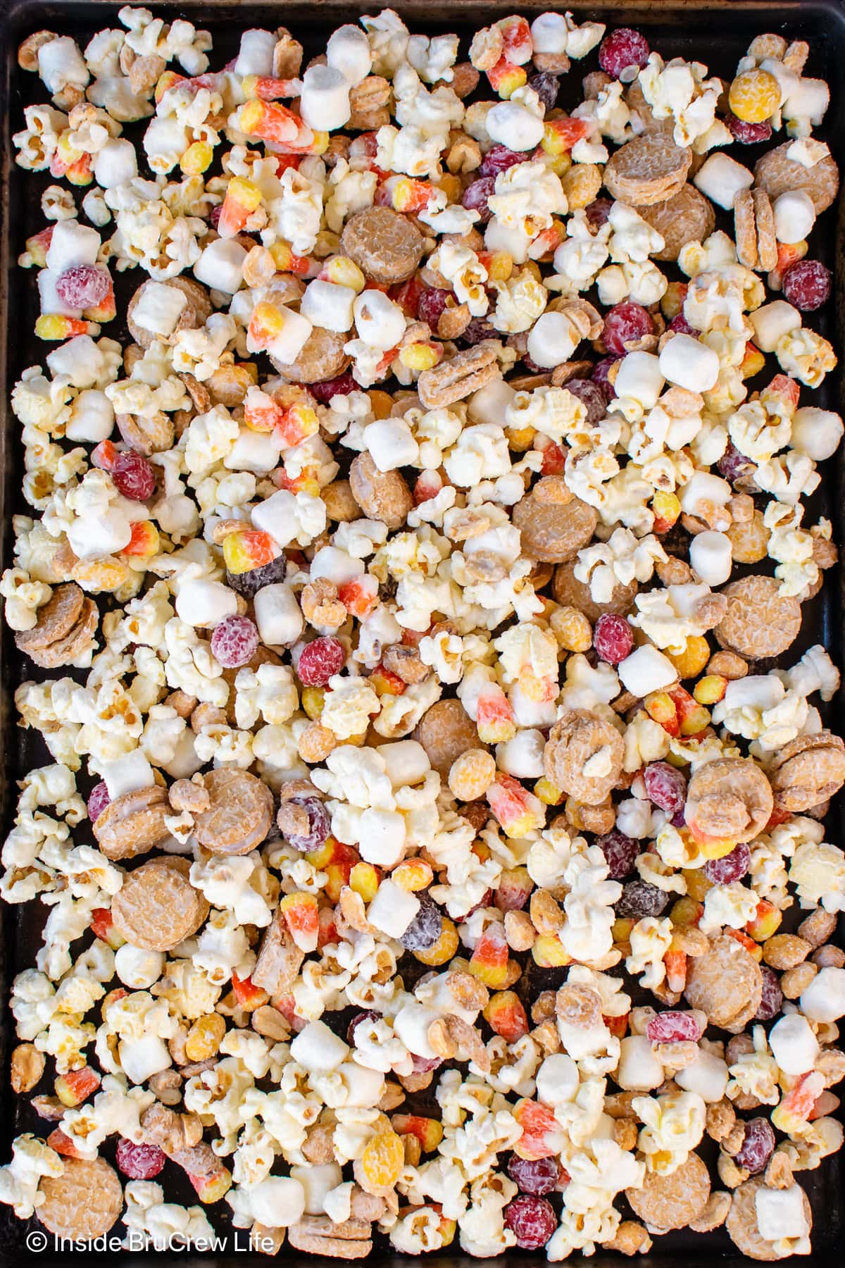 A pan of popcorn candy mix on a black tray.