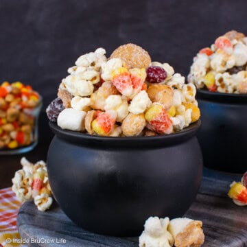 Black bowls filled with chocolate covered popcorn with candy corn.