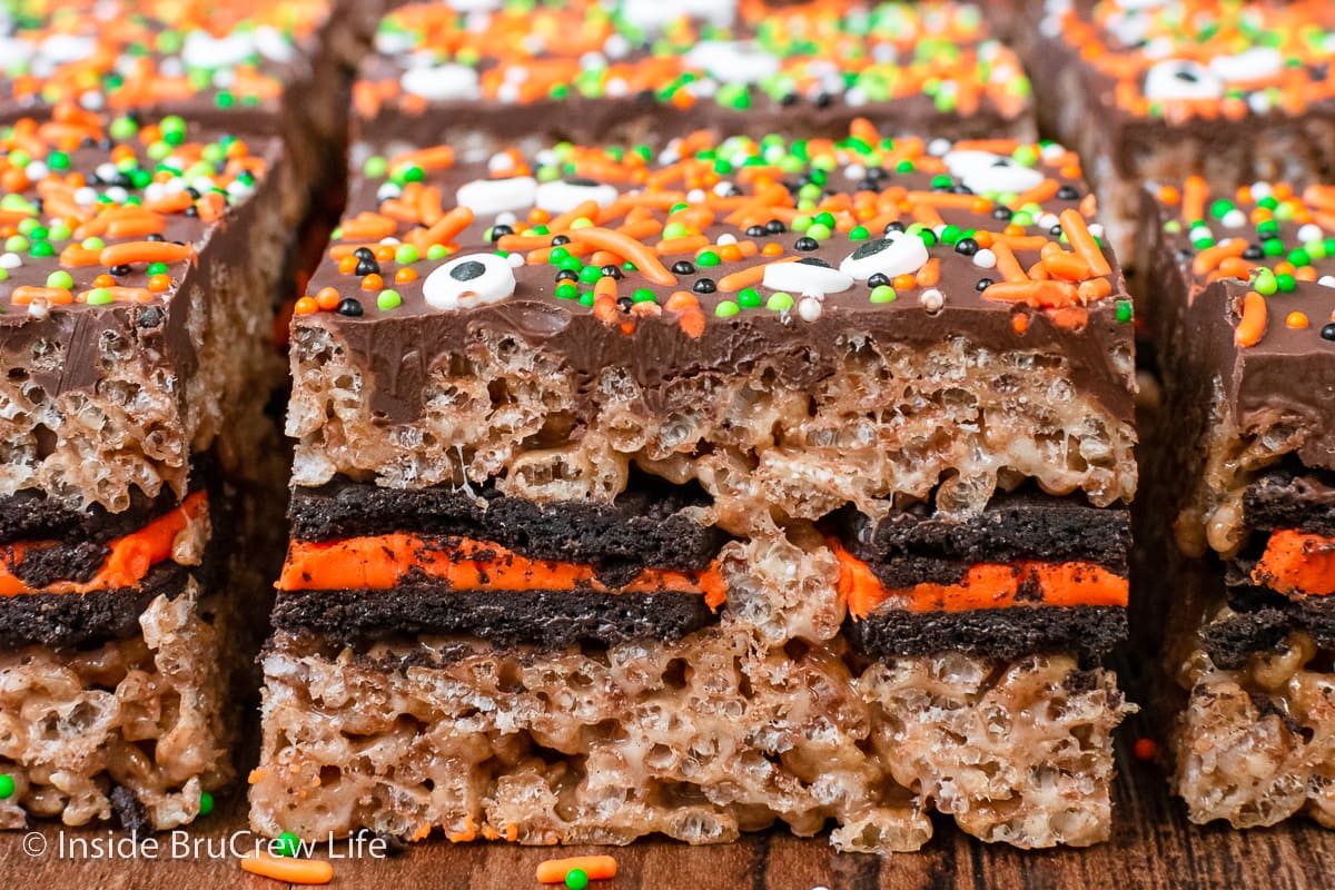 Squares of Oreo stuffed krispie treats on a brown board.