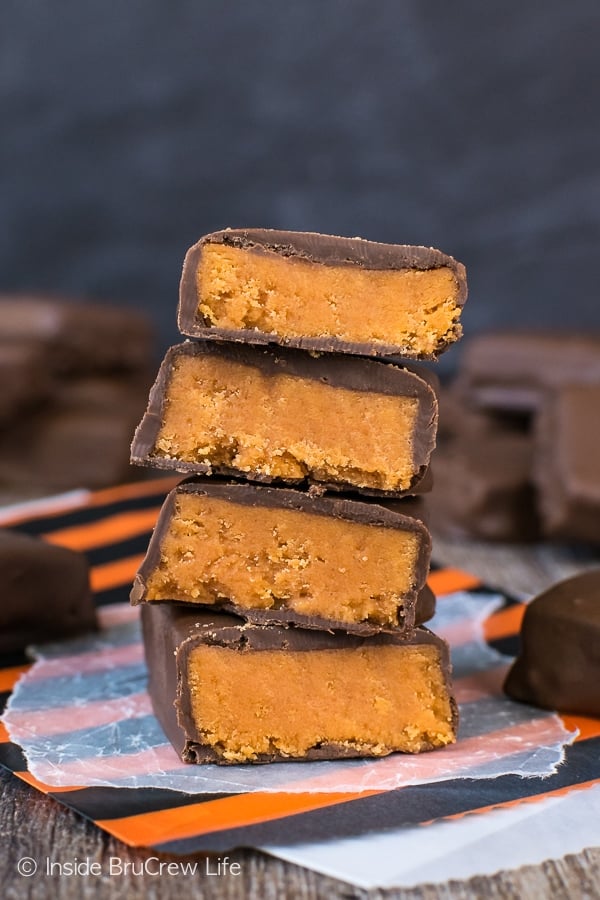A stack of Homemade Butterfingers cut in half and stacked on a dark board.