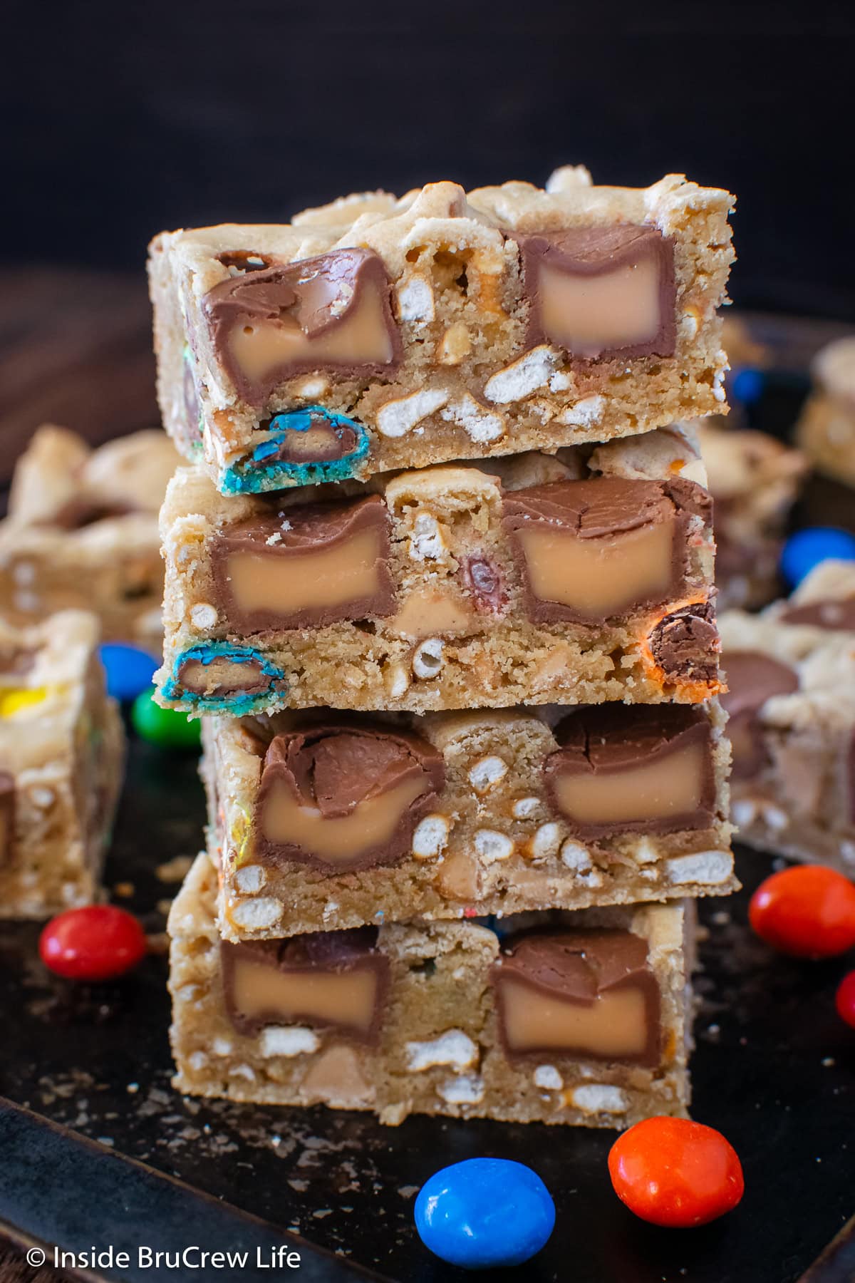 Four loaded cookie bars stacked in a pile.