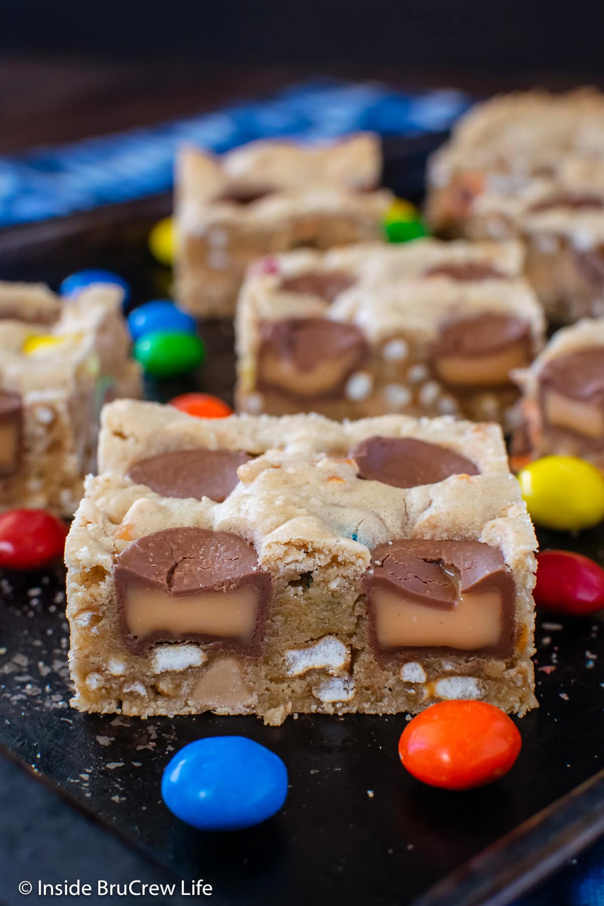 Candy cookie bars on a black sheet pan.