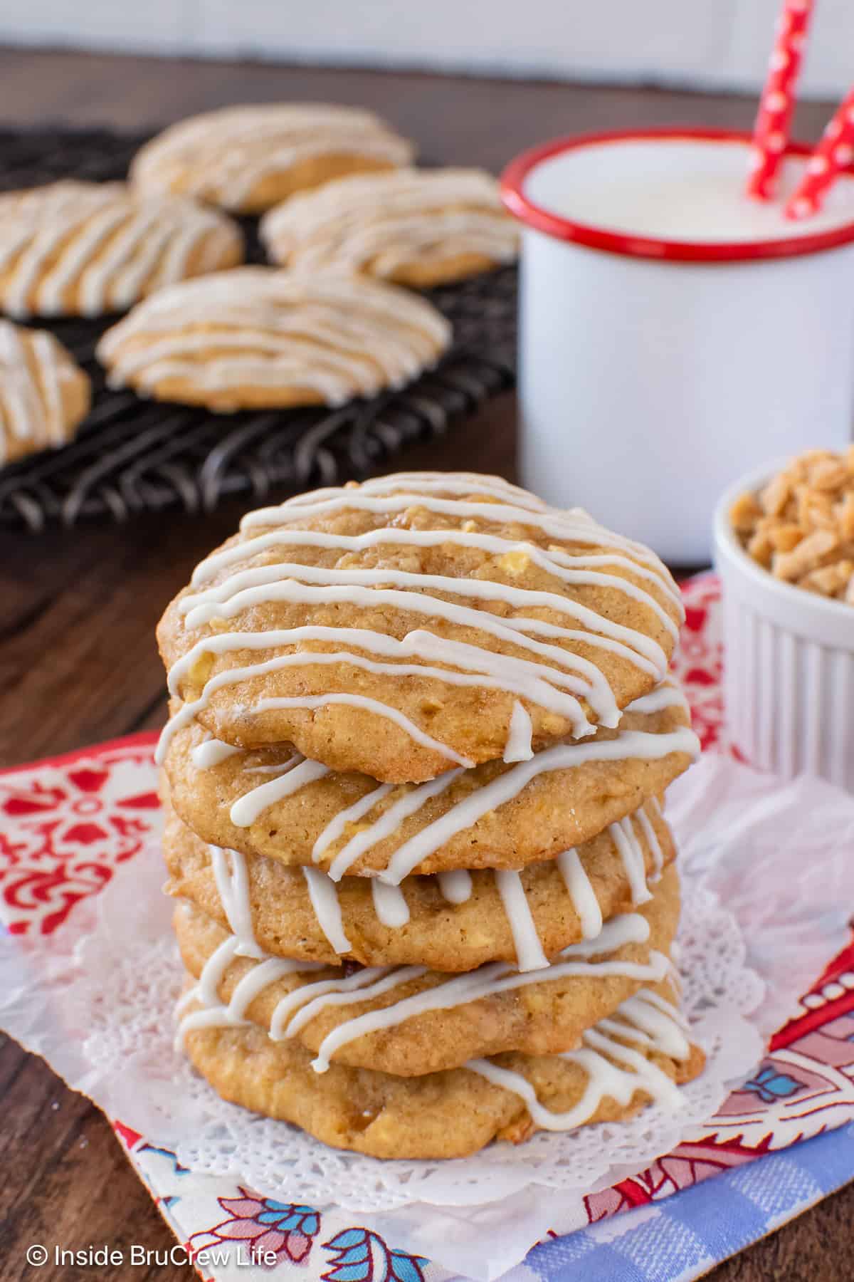 Four apple toffee cookies stacked together on a white doily.
