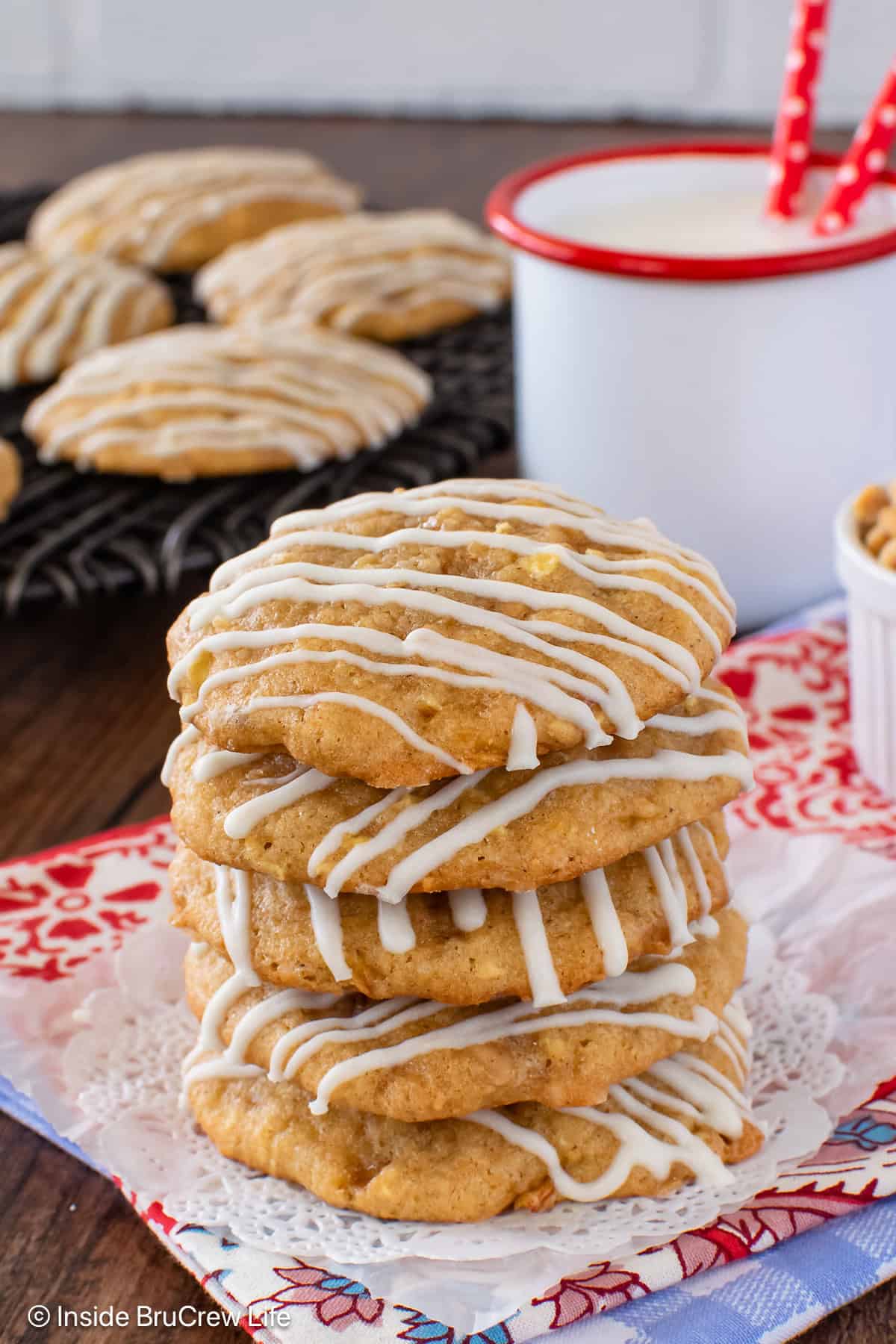 White chocolate drizzled toffee apple pie cookies stacked together.
