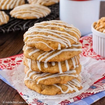 White chocolate drizzled toffee apple pie cookies stacked together.