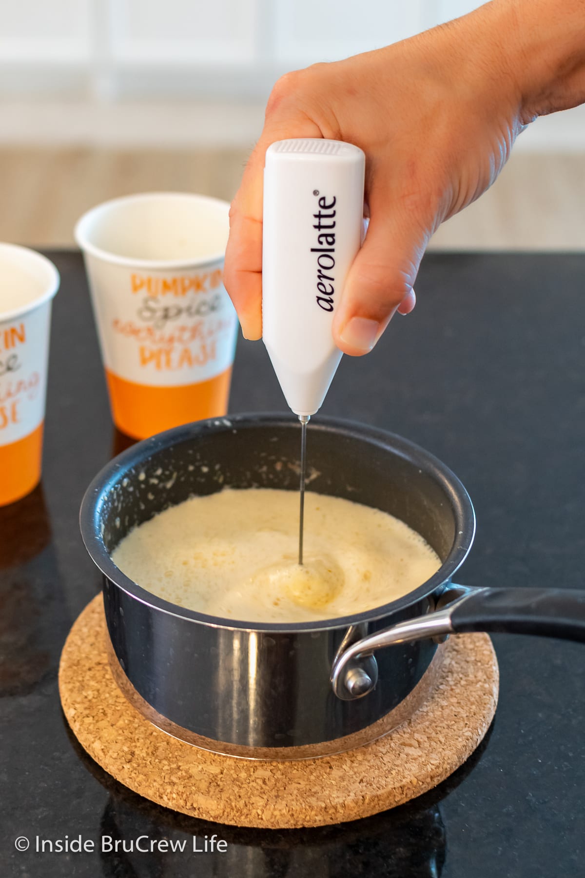 A saucepan with steamed milk being frothed.