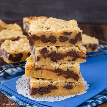 A stack of chocolate chip congo bars on a blue towel.