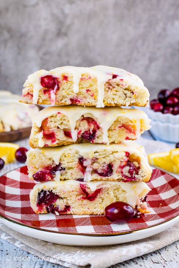 A red and white checkered plate with a stack of four cranberry orange scones on it.