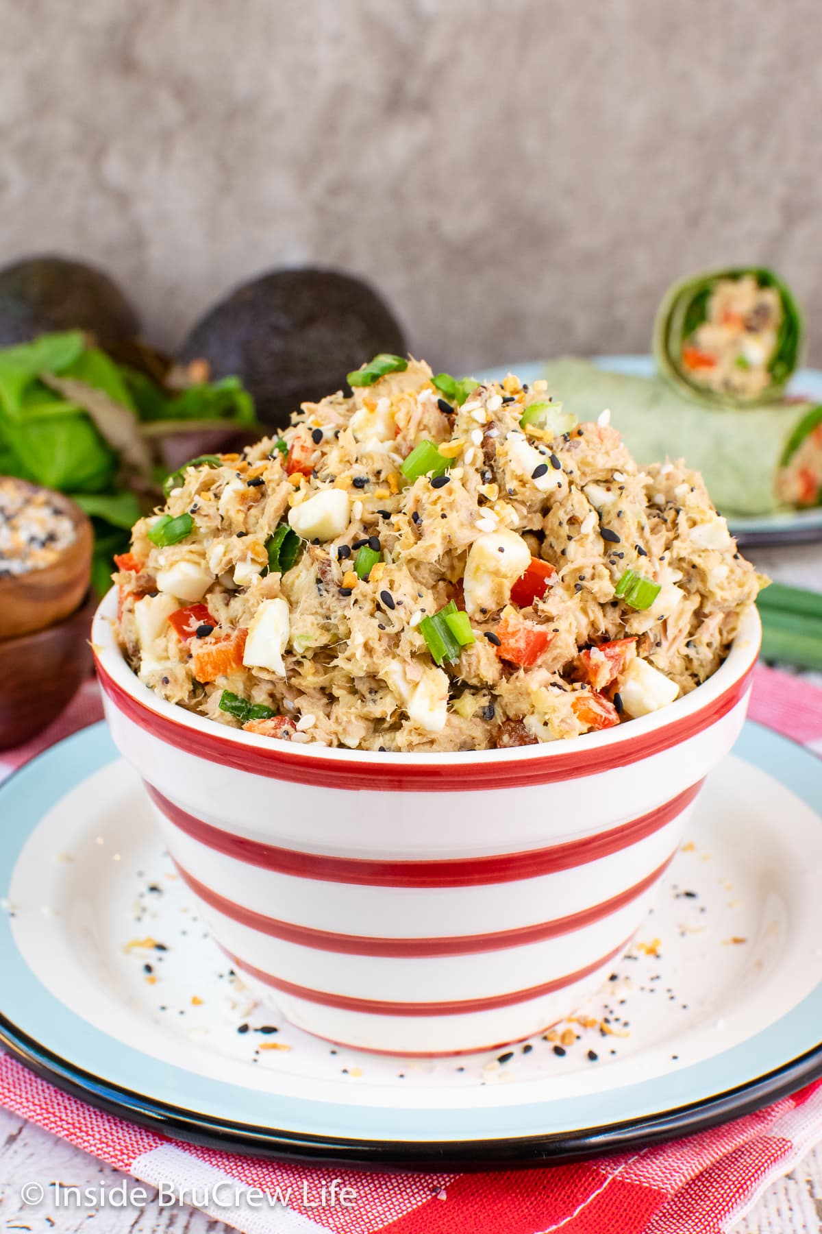 A red and white bowl filled with avocado tuna salad.