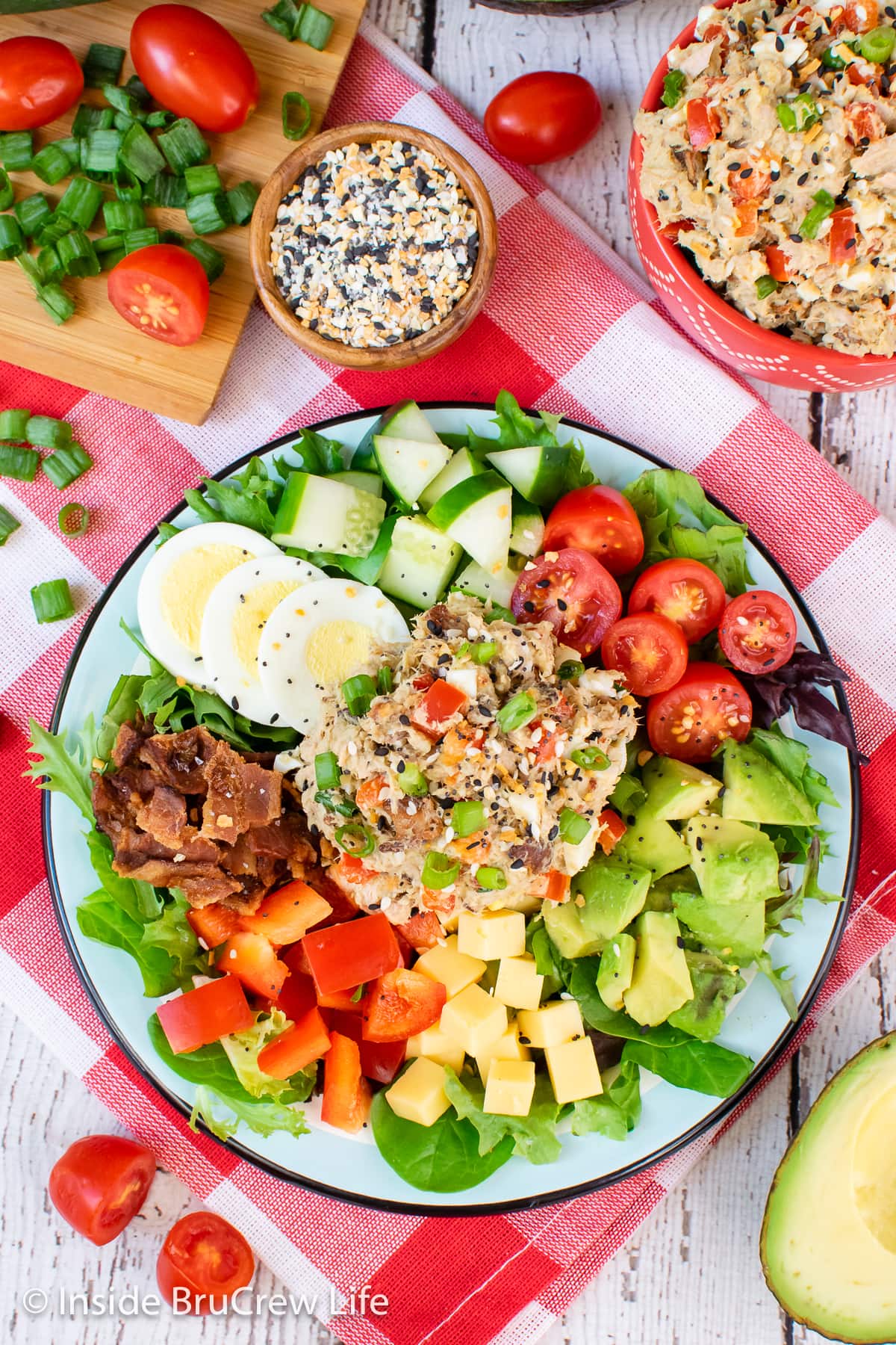 An overhead picture of a salad topped with a scoop of tuna salad.