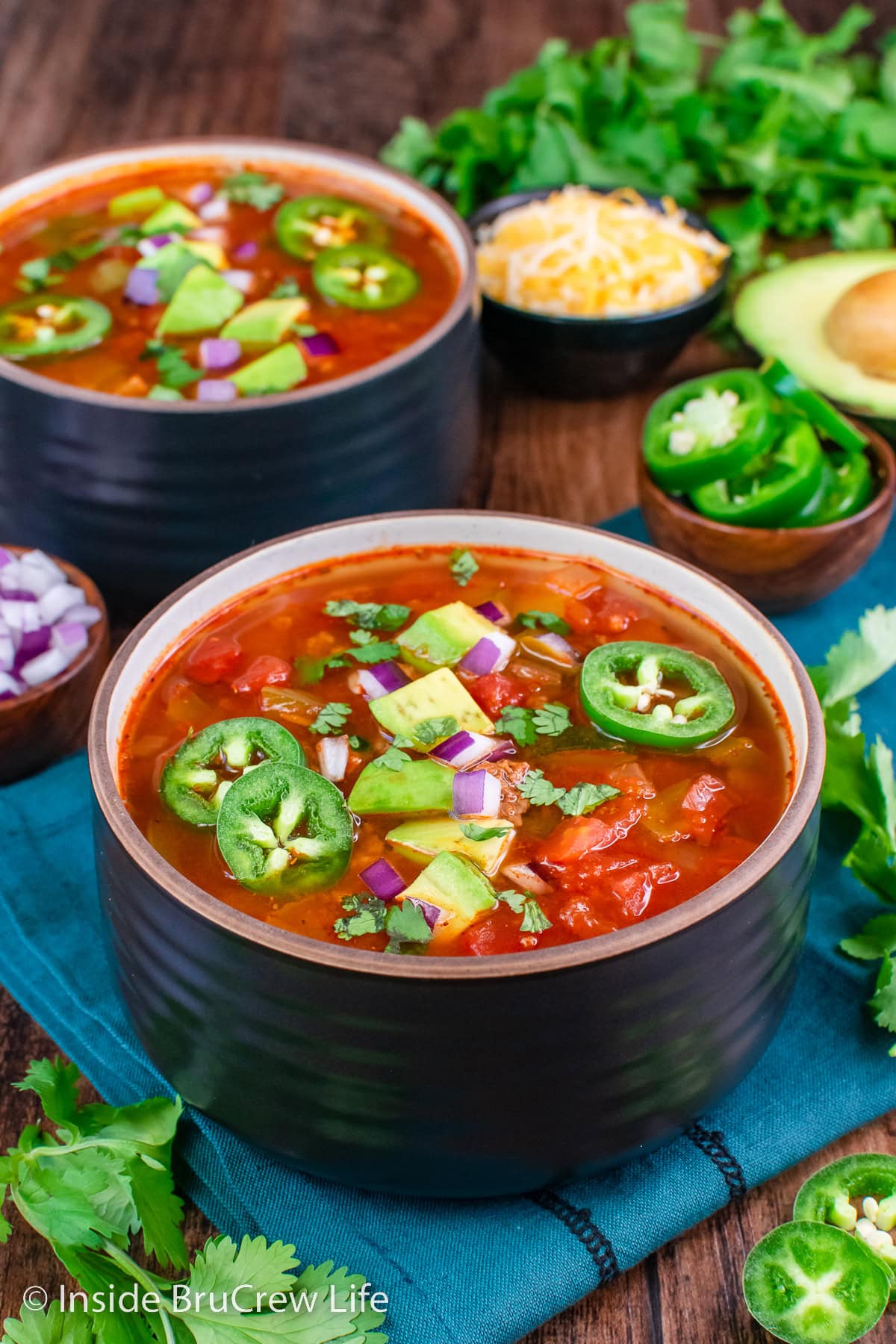 Two bowls of low-carb chili with toppings.