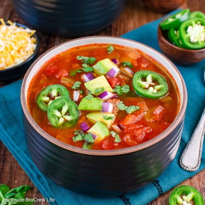 A bowl of low carb chili topped with jalapenos and avocado chunks.