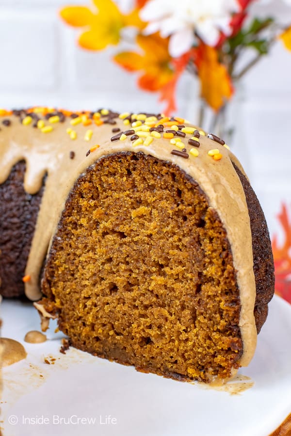 A close up picture of a slice of pumpkin bundt cake topped with maple glaze.