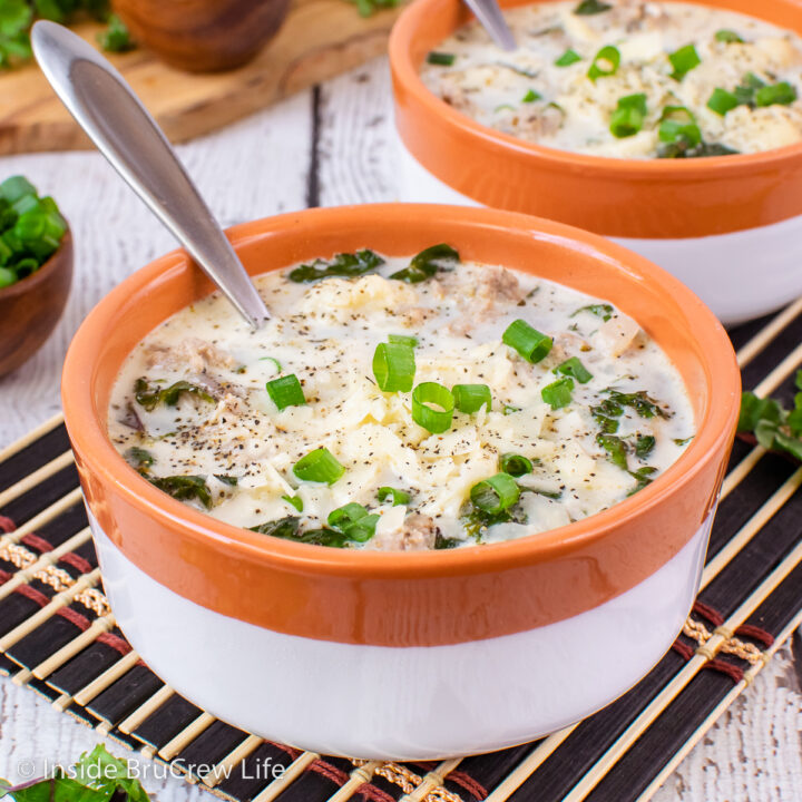 A bowl filled with a creamy sausage and kale soup.