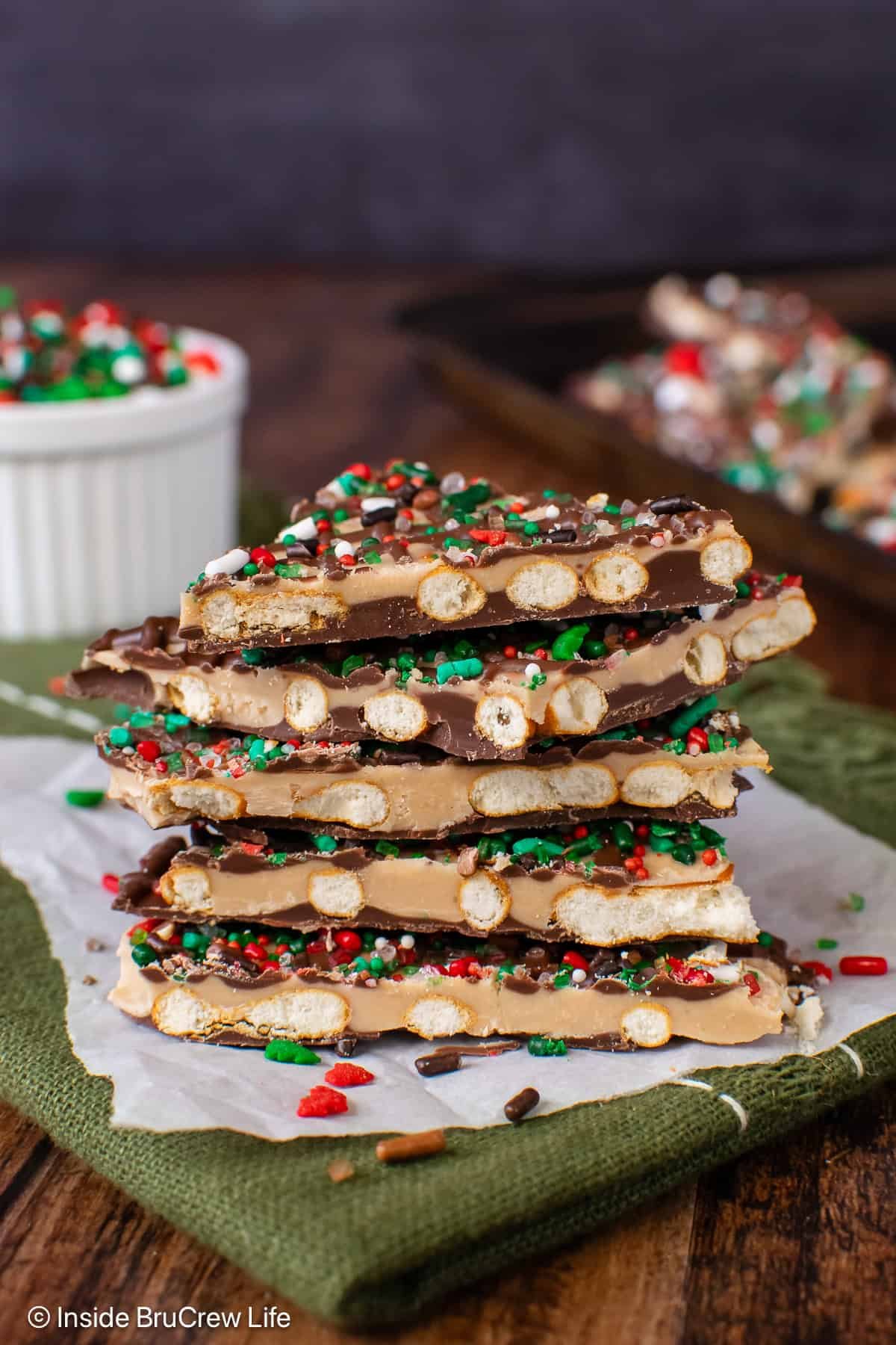 A stack of caramel chocolate pretzel bark on a sheet of parchment paper.