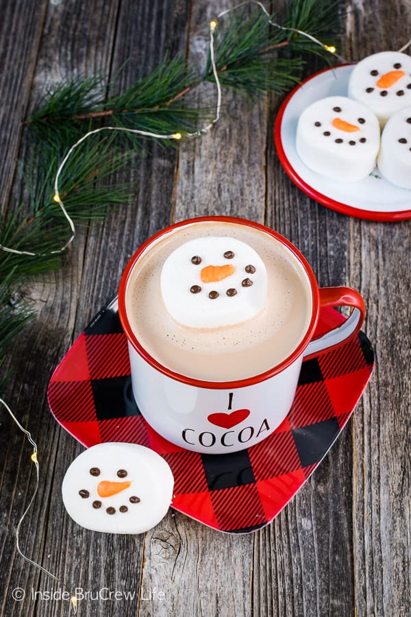 Marshmallow Snowmen head floating in a cup of hot cocoa.