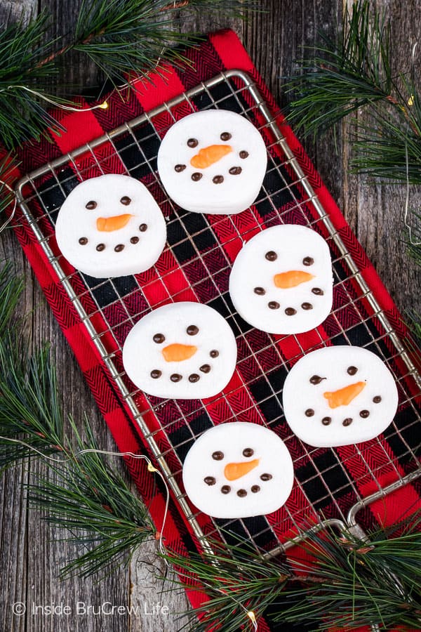 Overhead picture of 6 marshmallow snowman heads on a wire rack.