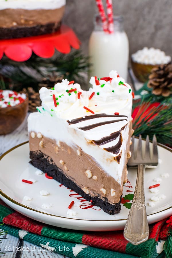 A slice of no bake chocolate cheesecake with a brownie crust on a plate.