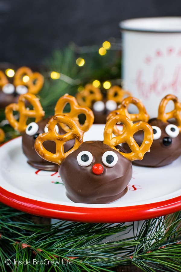 A white plate with a red rim with three Peanut Butter Reindeer on it.