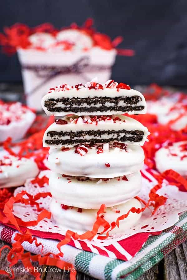 Four peppermint bark Oreos stacked on top of each other with red paper strips around it.