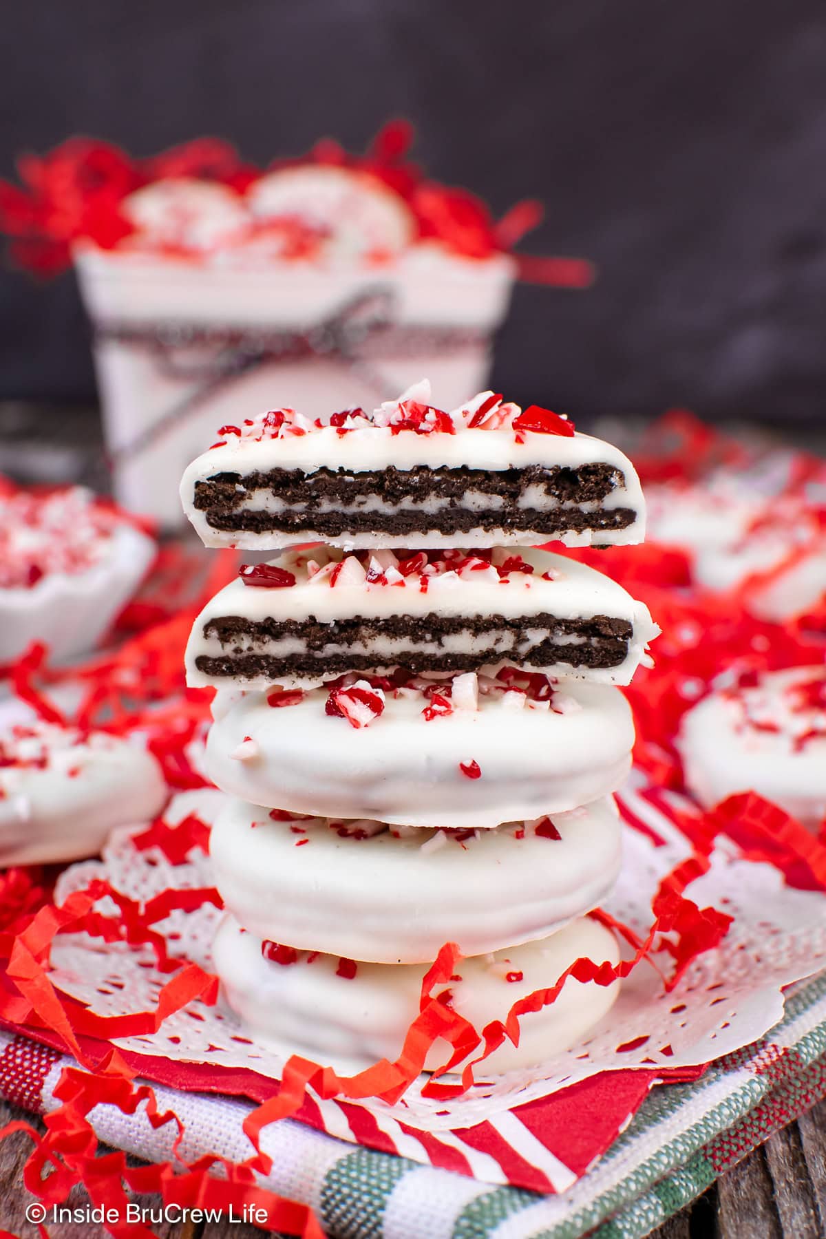 A stack of white chocolate covered Oreos with one cut in half.