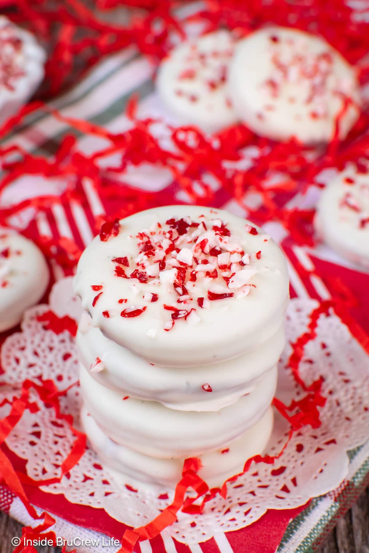 Four white chocolate covered peppermint Oreos in a stack.