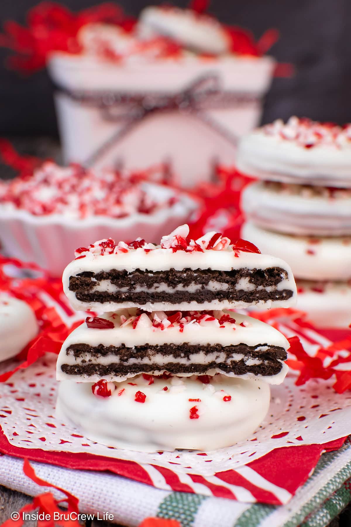 Two peppermint dipped Oreos with one cut in half.