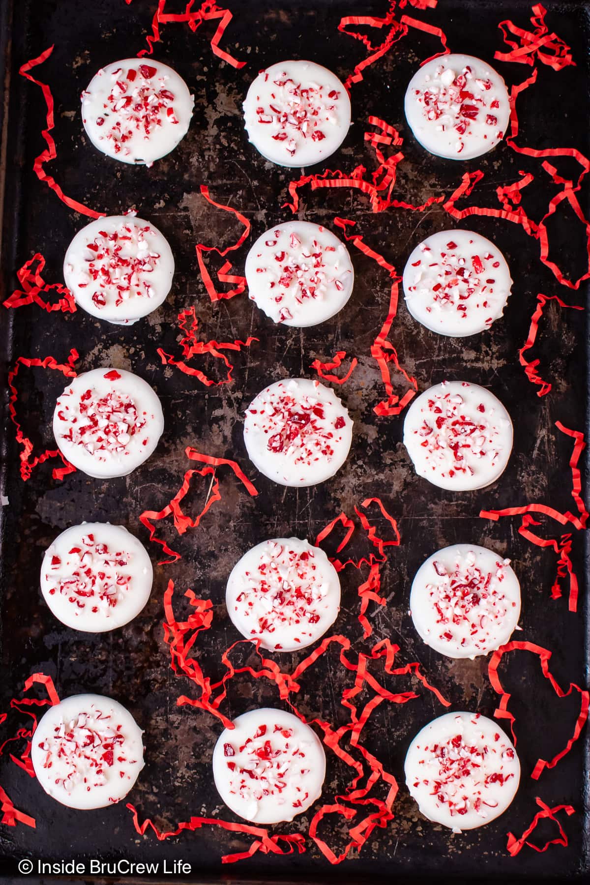 A black tray with peppermint white chocolate cookies lined on it.