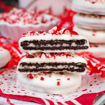 Two peppermint dipped Oreos with one cut in half.