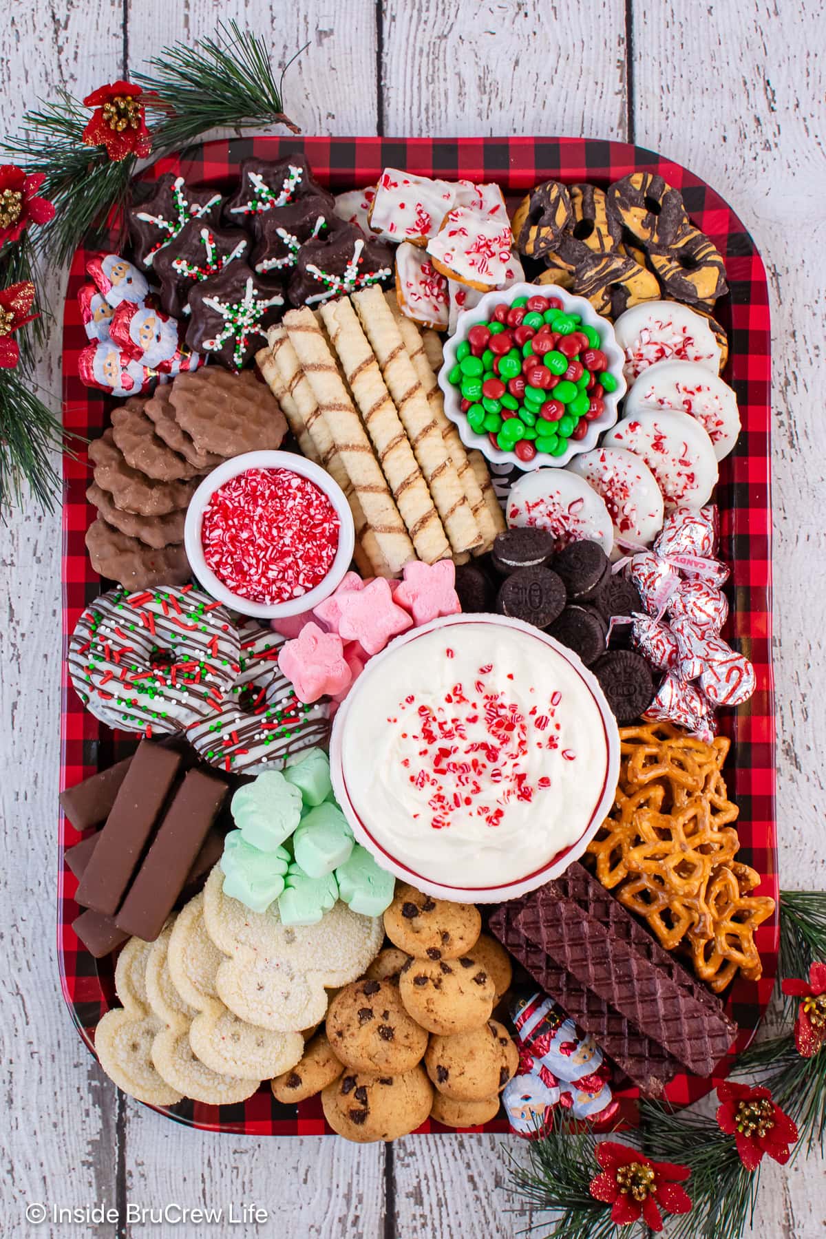 A tray of cookies with a bowl of creamy dip in the middle.