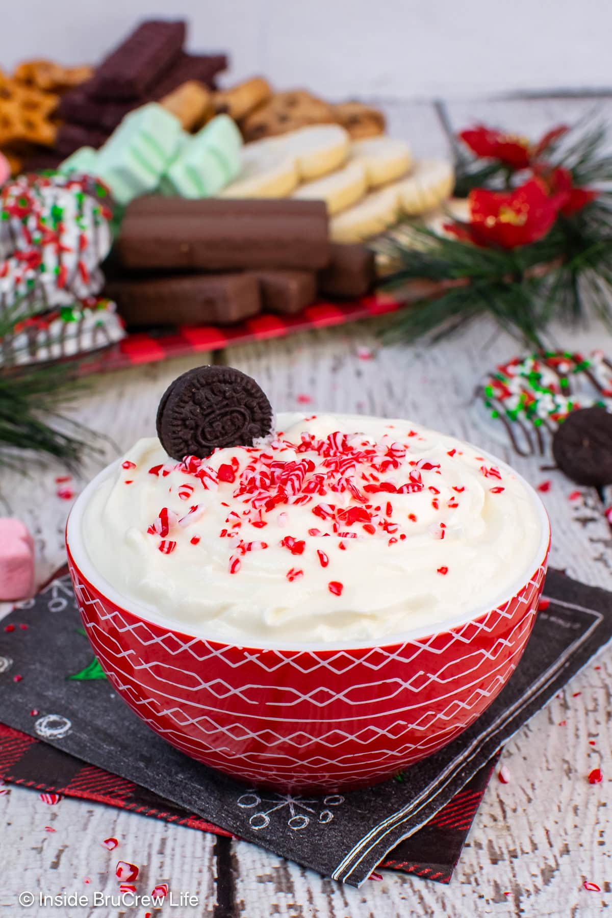 A red bowl filled with a creamy white chocolate peppermint dip.