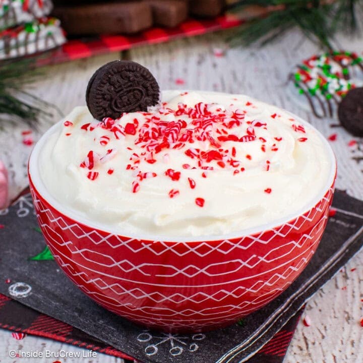 A red bowl filled with a creamy white chocolate peppermint dip.