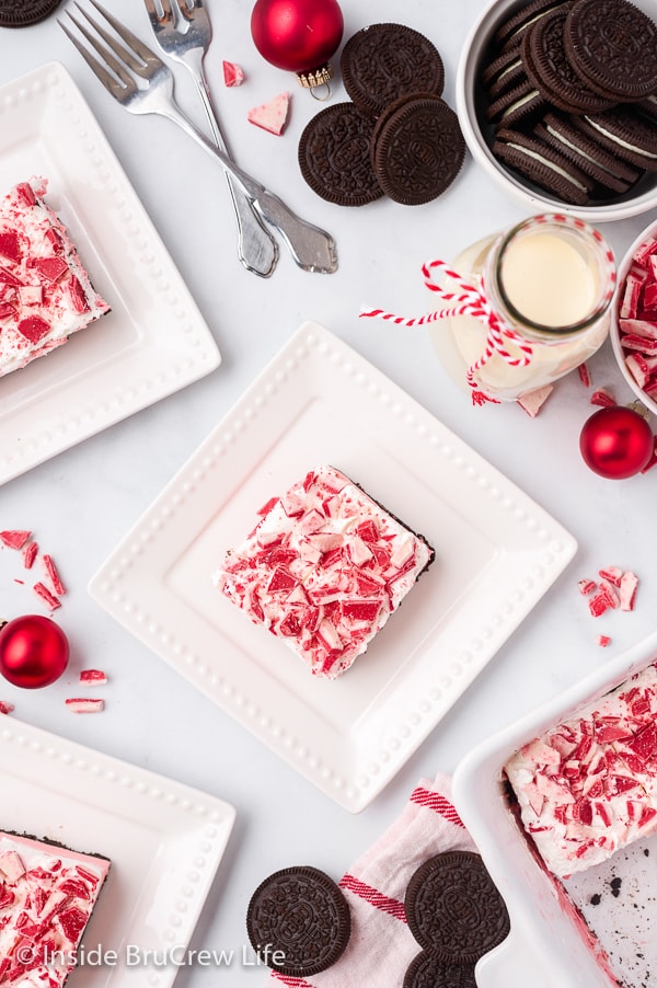 Overhead picture of white plates with squares of peppermint dessert on them.