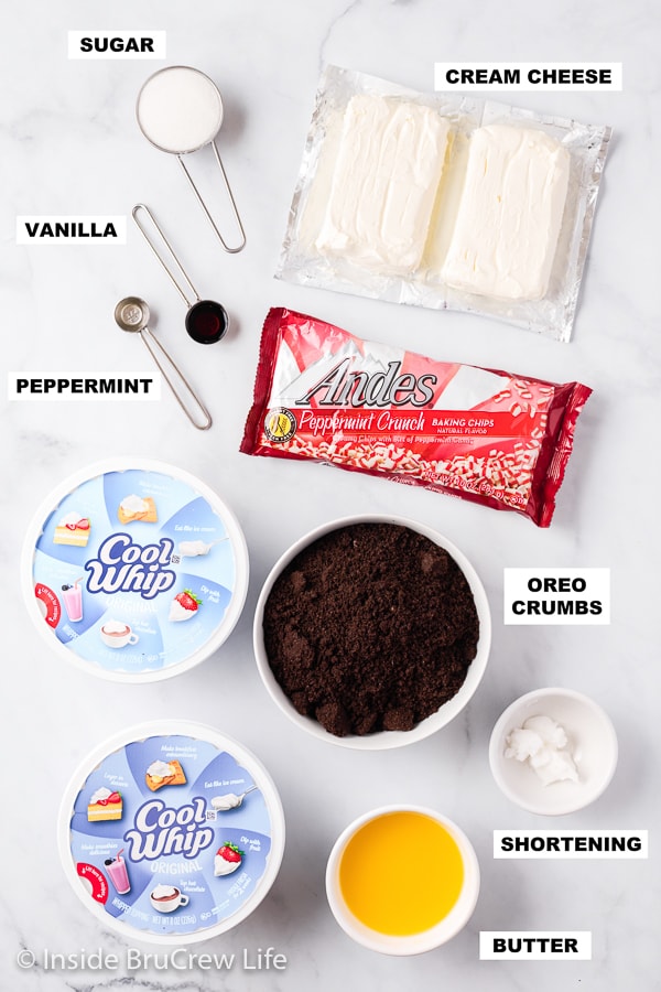 A white board with ingredients for a no bake peppermint cheesecake.