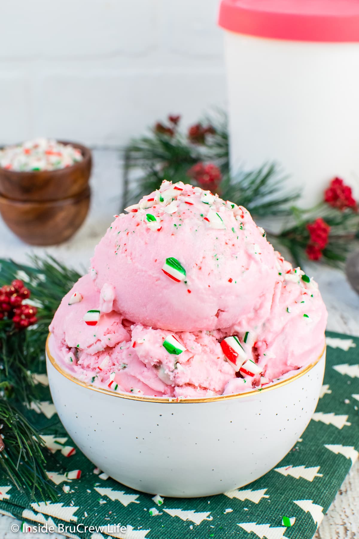 Pink ice cream scoops in a white bowl.