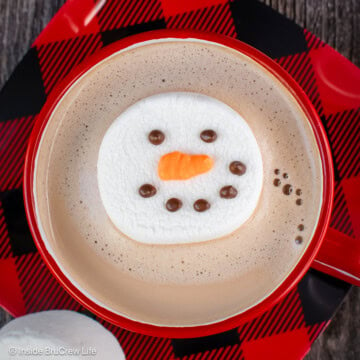 A marshmallow snowman floating in hot chocolate.