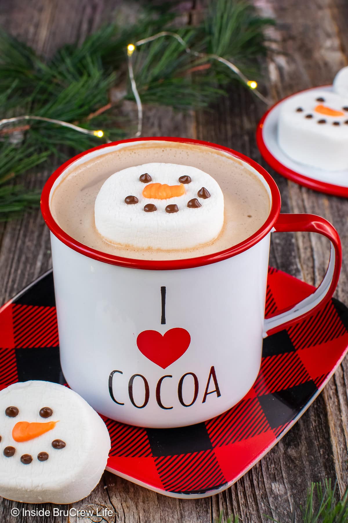 A cup of cocoa with a snowman topper.