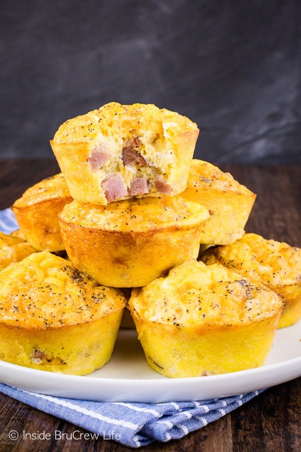 A stack of egg muffin cups made with ham and cheese on a white plate