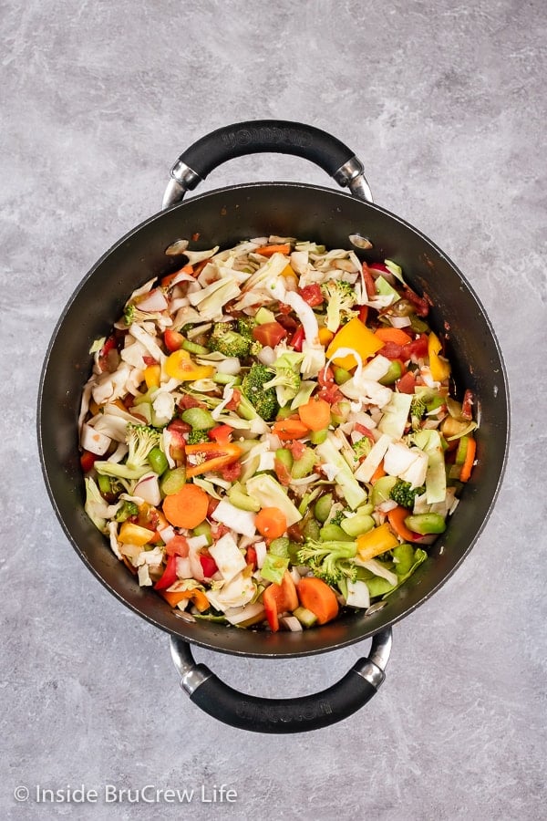 Overhead picture of a black pot filled with chopped veggies.