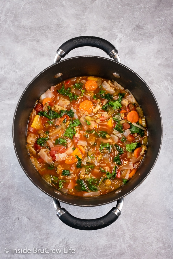 Overhead picture of a large black pot filled with cabbage detox soup.