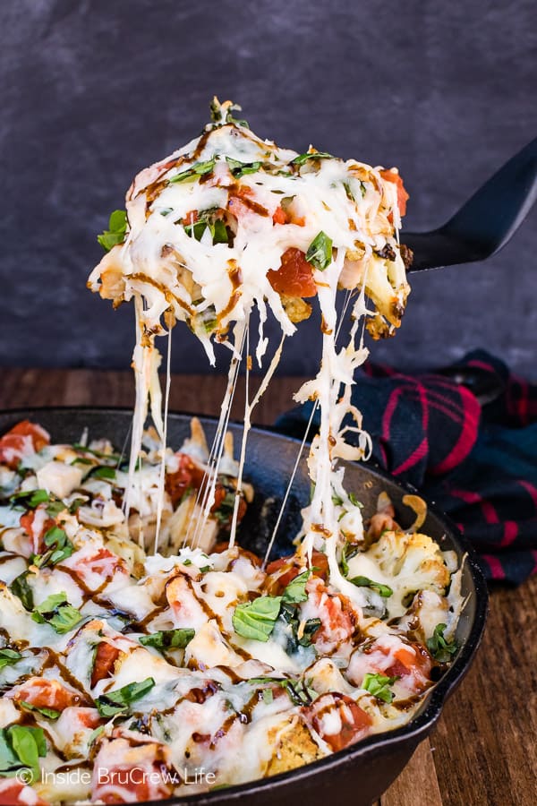 Chicken Caprese Cauliflower Nachos - gooey cheese, chicken, and tomatoes turns roasted cauliflower into a healthy and delicious appetizer. Make this easy recipe for game day parties! #appetizer #cauliflower #healthy #nachos #gameday