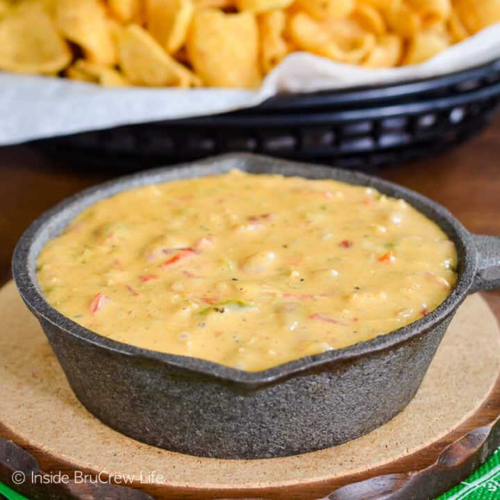 A black skillet filled with chicken queso dip in it.