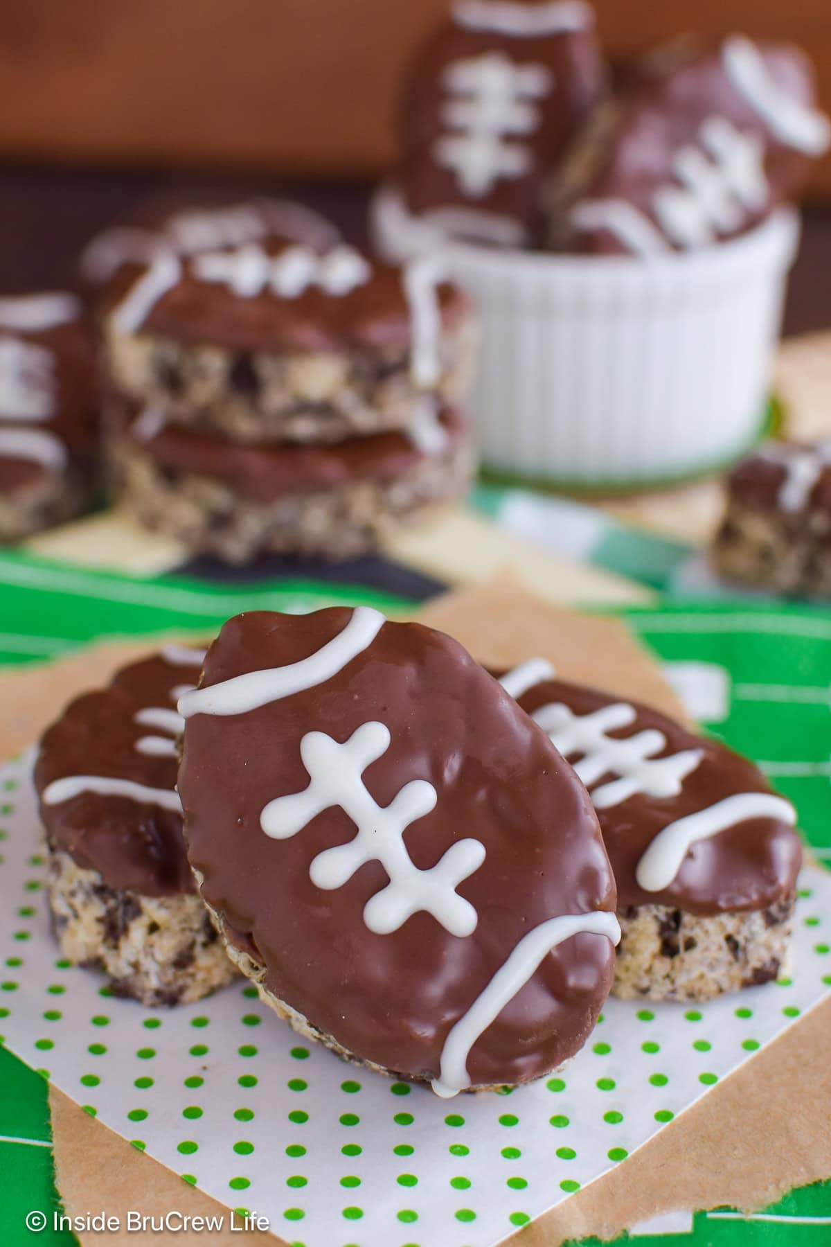 Football rice krispie treats stacked on a table.