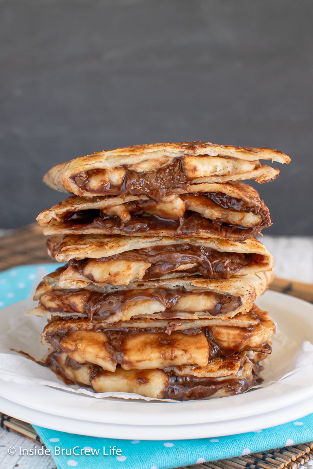 A large stack of chocolate and banana filled tortillas.